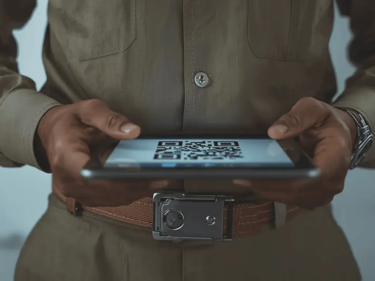 Close-up of a technician's hands holding a digital tablet to display a contactless QR code for secure business review collection.